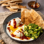 Hartige yoghurtbowl met harissa-eieren en libanees brood